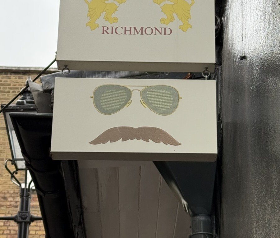 A shop sign in Richmond featuring sunglasses and a moustache